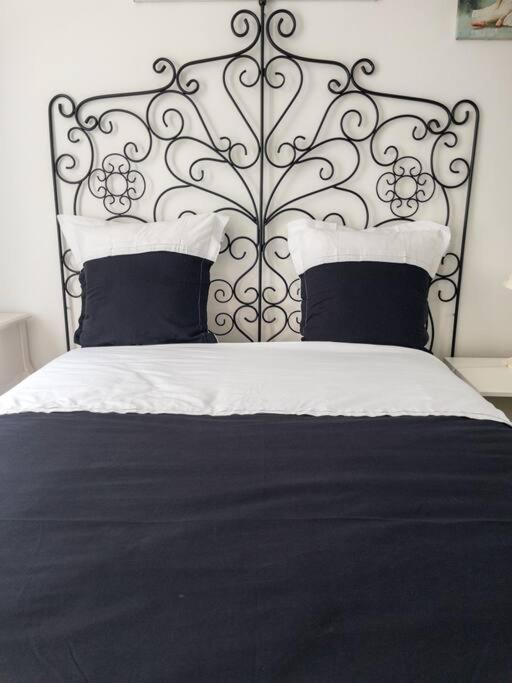 een slaapkamer met een zwart-wit bed met kussens bij Un parfait chez soi à Puteaux in Puteaux