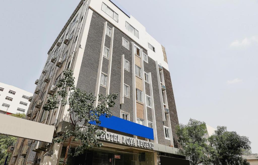 Un edificio alto con una señal azul. en Capital O Loya Legend Near Birla Mandir en Hyderabad