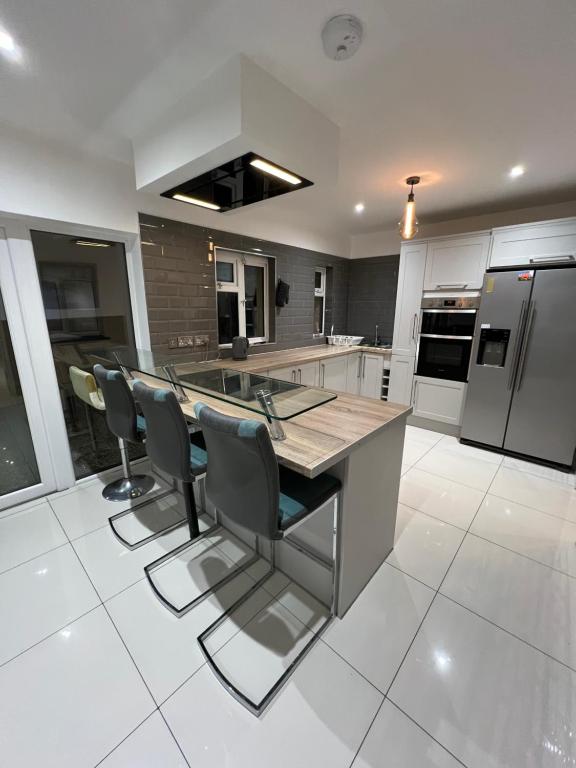 a kitchen with a large island with chairs in it at Lovely Home in Kimmage, Dublin in Dublin