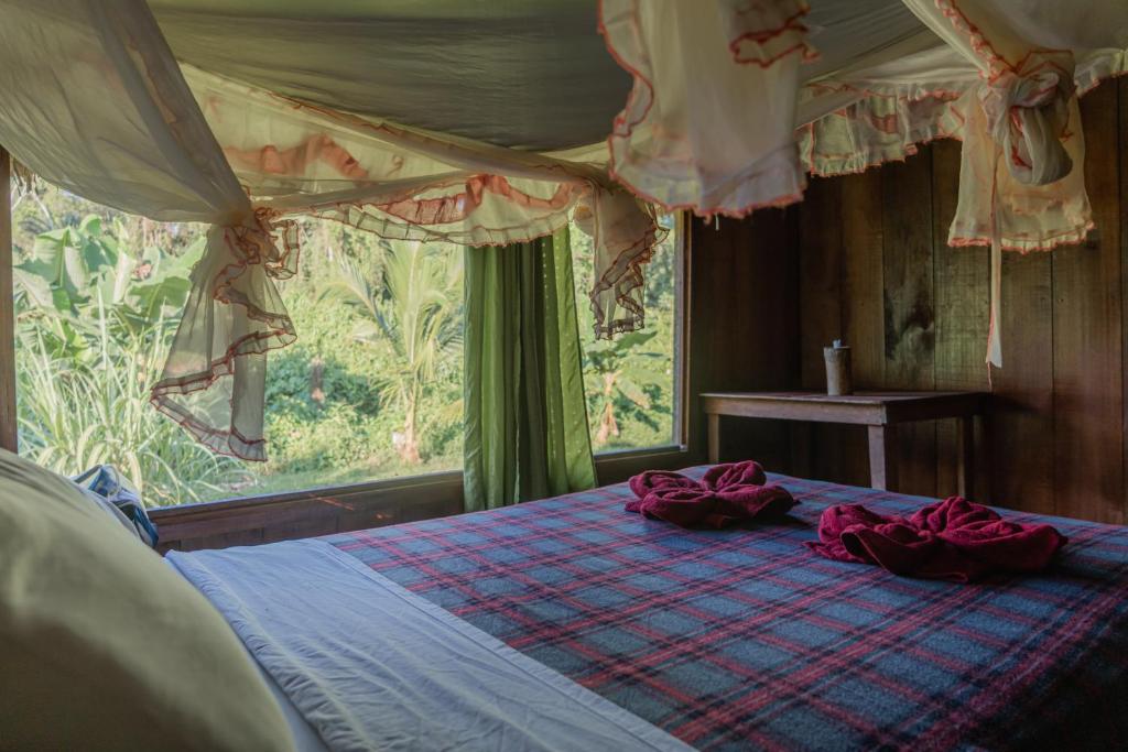 Un dormitorio con una cama con almohadas rojas. en Kichwa Lodge en Aguarico