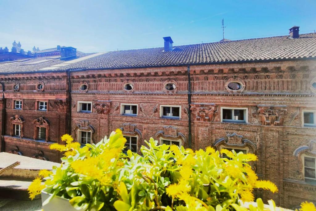 an old brick building with yellow flowers in front of it at Ai Tetti Carignano in Turin