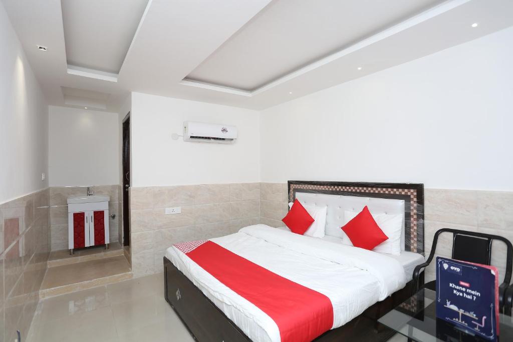a bedroom with a bed with red pillows at Hotel Pearl in Karnal