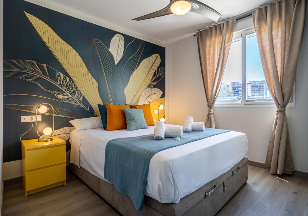 a bedroom with a bed with a blue and yellow wall at Torremolinos Centro terraza wifi parking ascensor a la playa a 5 min in Torremolinos