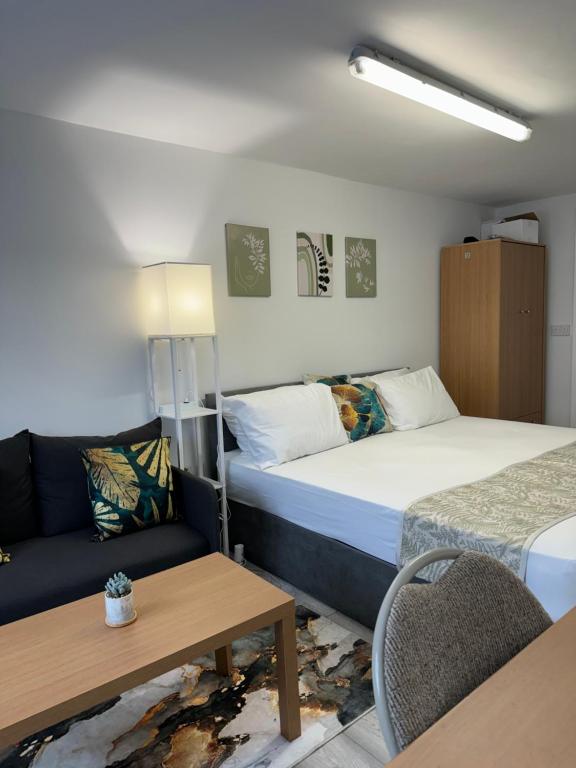 Habitación de hotel con 2 camas y sofá en Posh Executive Studio London, en Thamesmead