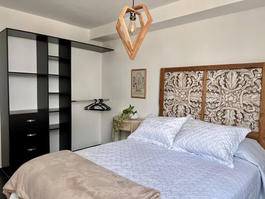 1 dormitorio con cama y lámpara de araña en Casa 11, en Guatemala