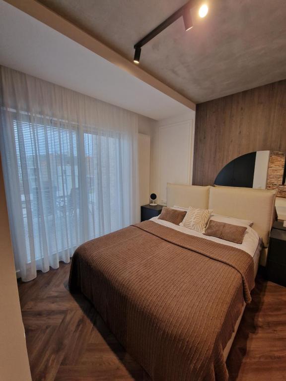 a bedroom with a large bed and a large window at Apartament G13 Nautica Resort Giżycko in Giżycko