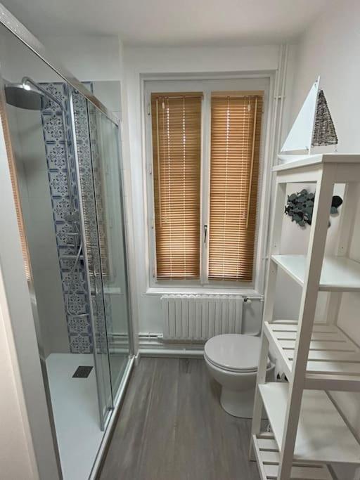 a bathroom with a toilet and a glass shower at Villa Roc Vaudieu - Charmante maison de pêcheurs in Étretat
