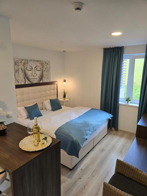 a bedroom with a bed and a table with a table at Apartmány Pulse in Podhájska