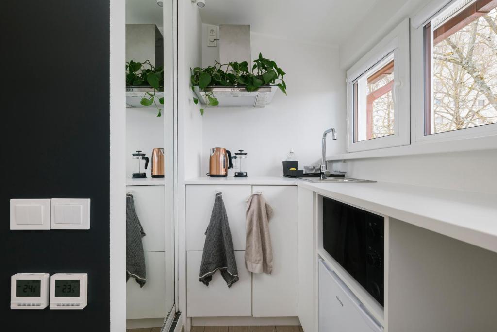 a white kitchen with white cabinets and a window at Apartment for one - grey in Tallinn