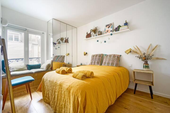 une chambre avec un grand lit avec une couverture jaune dans l'établissement Superbe appartement lumineux proche du Marais, à Paris