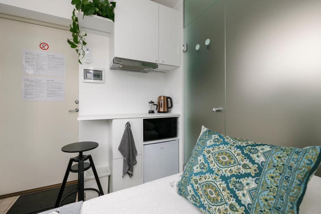 a small kitchen with a couch and a pillow at Apartment for one - white in Tallinn
