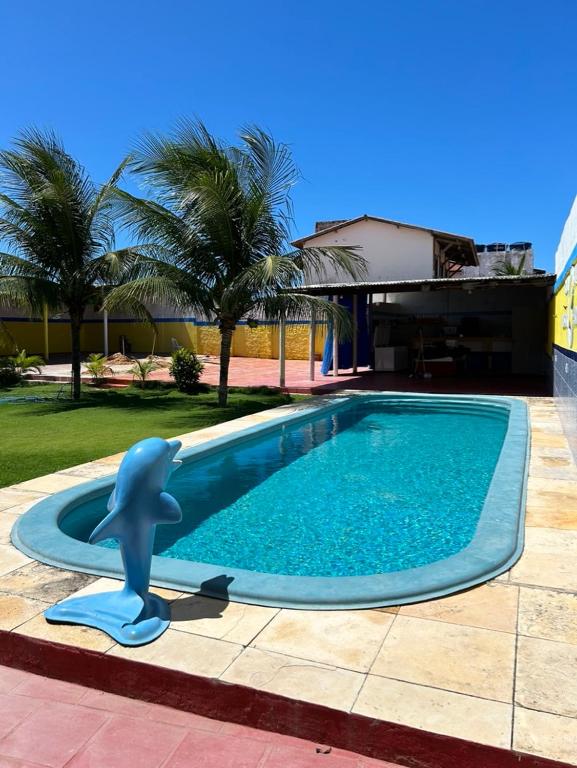 a swimming pool with a blue dolphin in a yard at Dunas Bar&Hotel in Canoa Quebrada