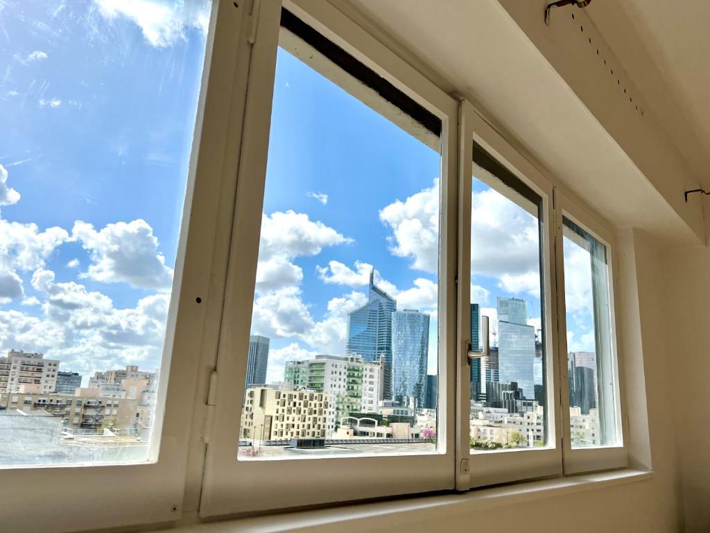 a window with a view of the city at Confortable et Chic Appartement in Courbevoie