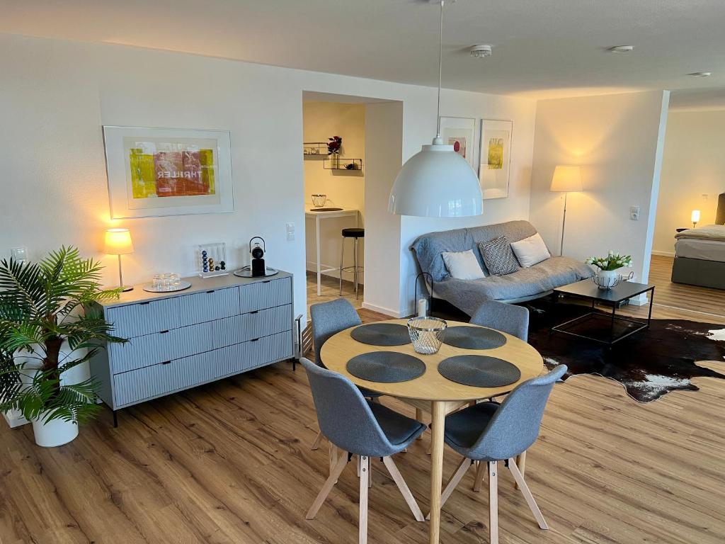 a living room with a table and a couch at Modernes Studio-Apartment in toller Waldrand-Lage in Kaiserslautern