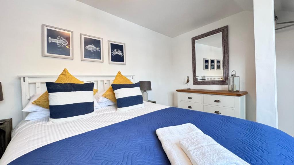 a bedroom with a blue and white bed and a mirror at Heart of DARTMOUTH TOWN CENTER and with own PRIVATE PARKING - These Two Traditional Georgian SUPER STYLISH DUPLEX APARTMENTS are NEWLY REFURBISHED and have a CONNECTING DOOR For Larger Groups!!! in Dartmouth