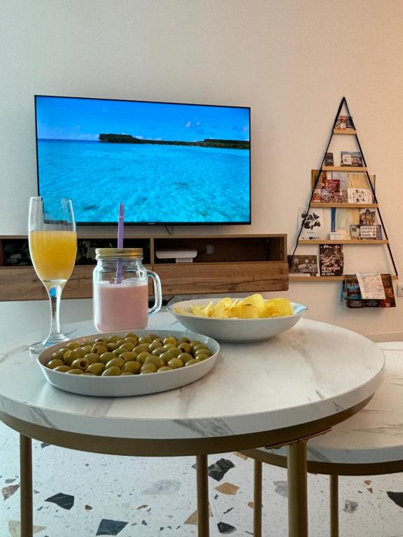 einen Tisch mit zwei Schalen Oliven und einen Fernseher in der Unterkunft La Casita Real in Vigo