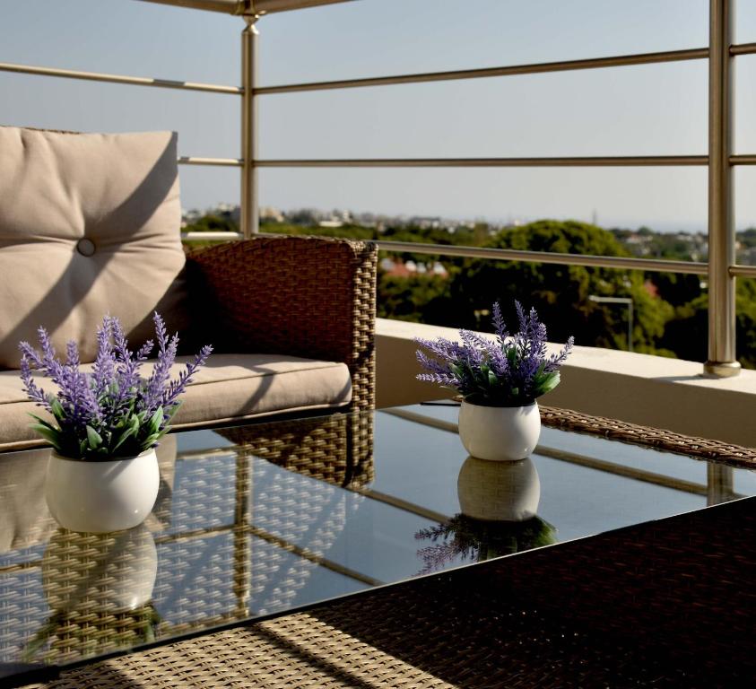 a glass table with two vases with purple flowers on it at Luxury Rhodian Panorama in Ixia