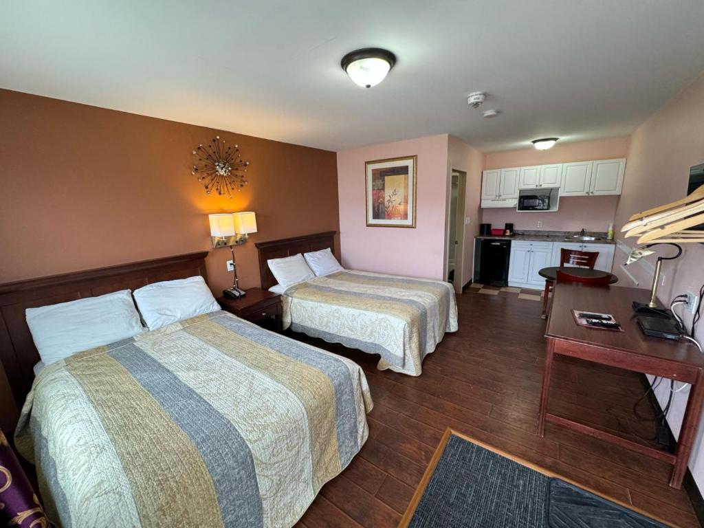 a hotel room with two beds and a kitchen at Travel Inn Cochrane in Cochrane