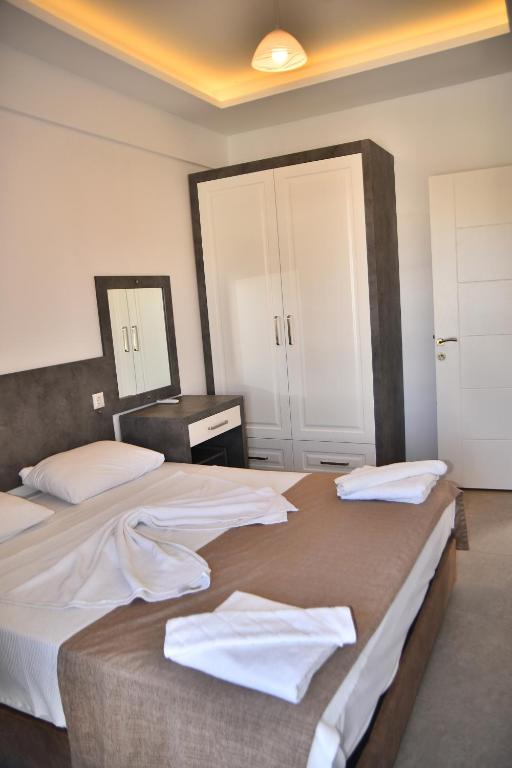 Habitación de hotel con 2 camas con sábanas blancas en Garden De Padre, en Antalya