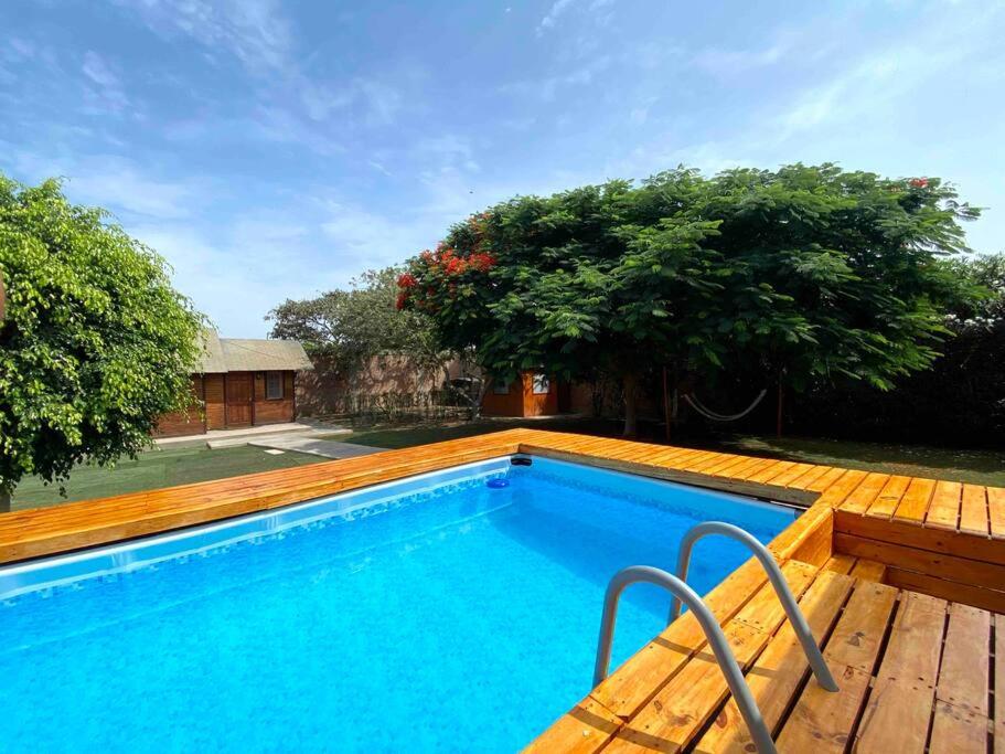 a large swimming pool with a wooden deck and trees at Groën Chincha® Casa de Campo centrica y turistica in San Pedro