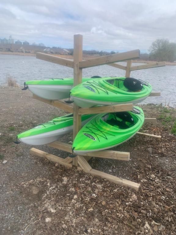 a group of kayaks on a rack next to the water at Sun Chaser Bay in Carrying Place