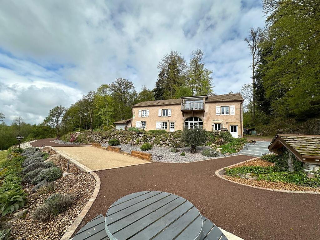 a large house with a walkway in front of it at GITE DU BOIS DES HAUTS LES MILLE ETANGS in La Lanterne-et-les-Armonts