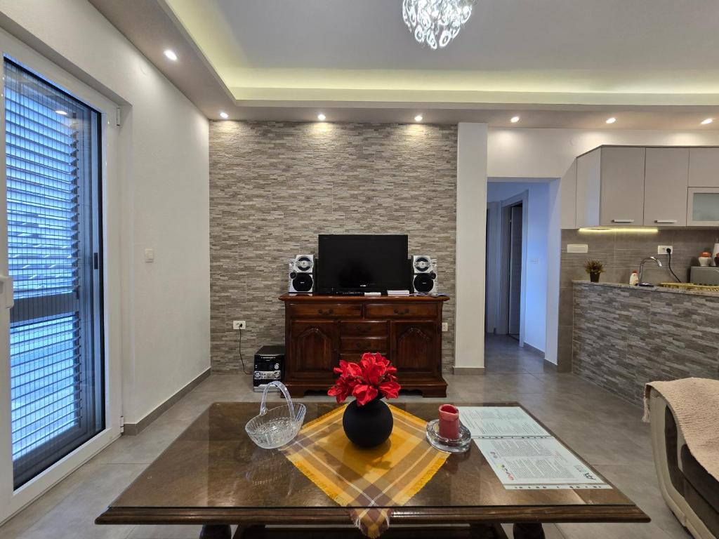 una sala de estar con una mesa con flores. en Apartment Angel en Kotor