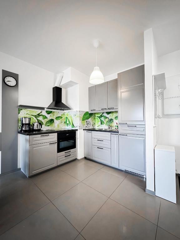 a large white kitchen with white cabinets and appliances at 306 BALTICA Hallera 223 Apartamenty zresetuj się w Gdańsku blisko morza in Gdańsk
