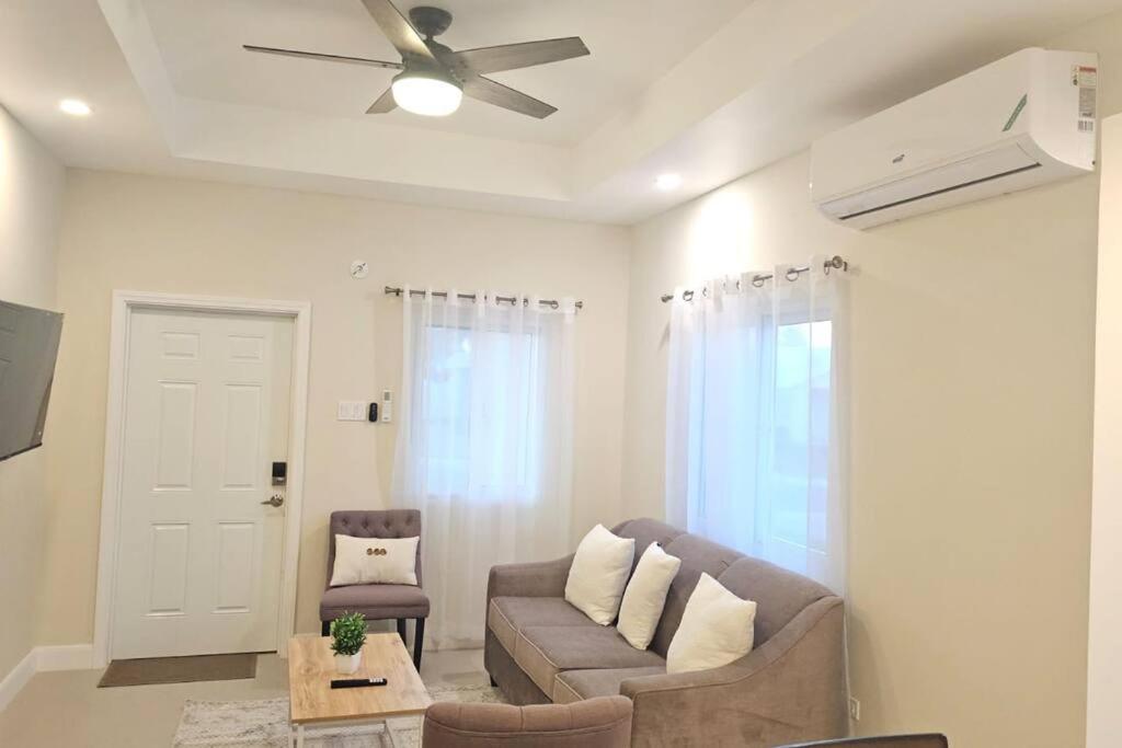 a living room with a couch and a ceiling fan at Casa Fortuna in Lucea, Hanover in Point