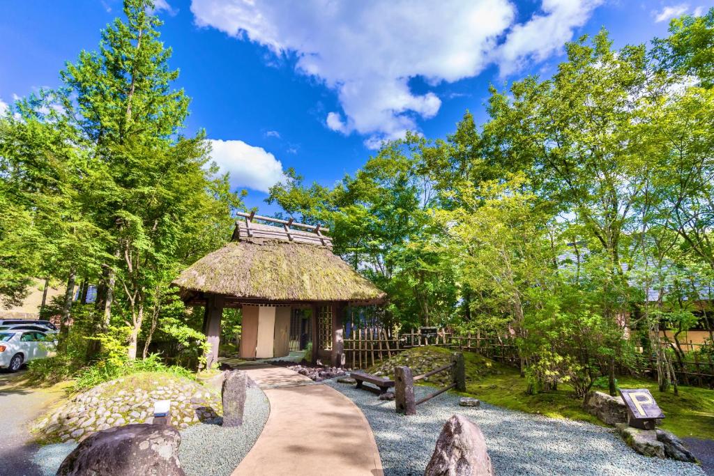 a building with a thatch roof in a park at Satonoyu Waraku 13 years or older in Minamioguni