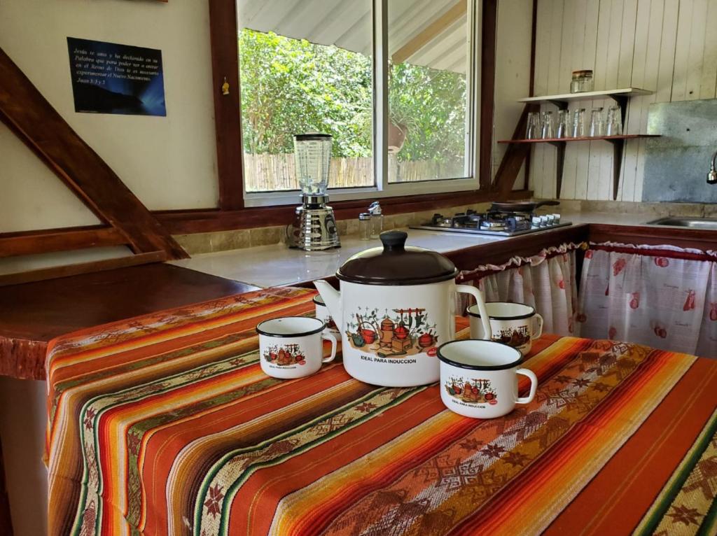 a kitchen counter with four tea cups on a table at Casa Noe - Noe House in Macas