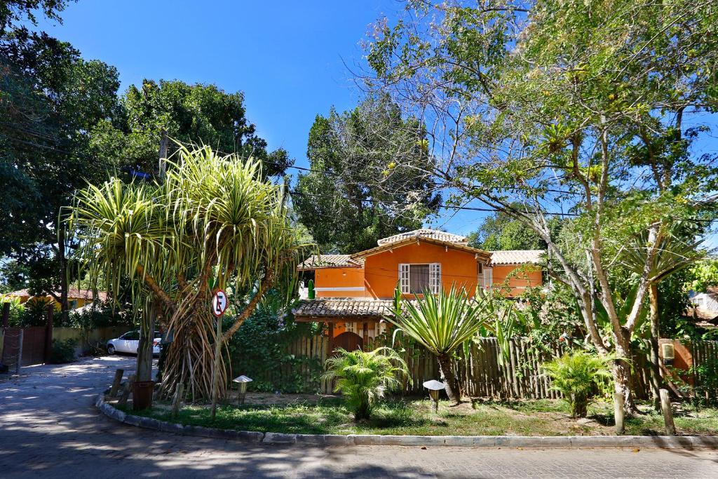 une maison orange avec des arbres devant elle dans l'établissement Casa Charmosa, 3 quartos ao lado do Quadrado, à Trancoso