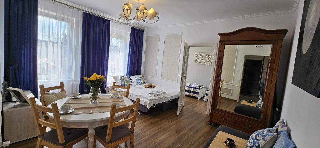 a living room with a table and a room with a couch at Apartament Gdańska in Gdańsk