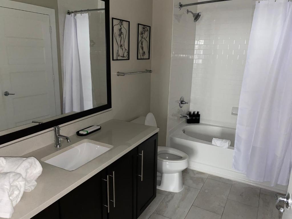 a bathroom with a sink and a toilet and a tub at CozyN Buckhead in Atlanta