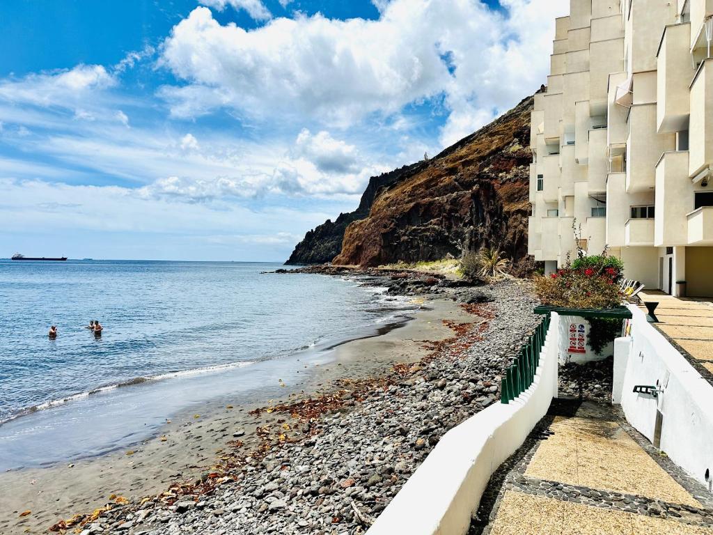 a beach with two people swimming in the ocean at Pambnb - Modern Beachfront Apartment Hideaway in Santa Cruz de Tenerife