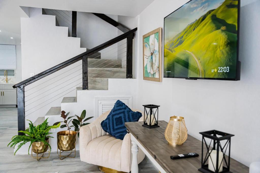 a living room with a table and a staircase at Villa 409C in Jolly Harbour