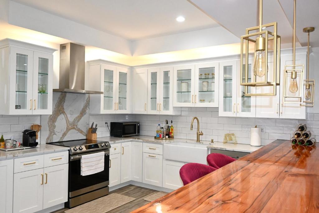 uma cozinha com armários brancos e uma mesa de madeira em Modern cozy home, pet friendly em Wolcott