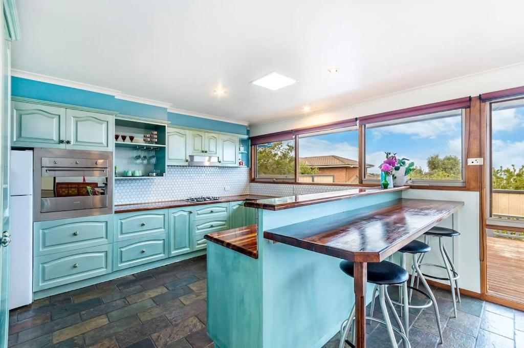 a kitchen with blue cabinets and a large island at Beachview Bungalow Warrnambool in Warrnambool
