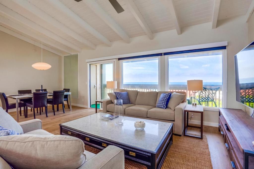 een woonkamer met een bank en een tafel bij Azure Sky in Solana Beach