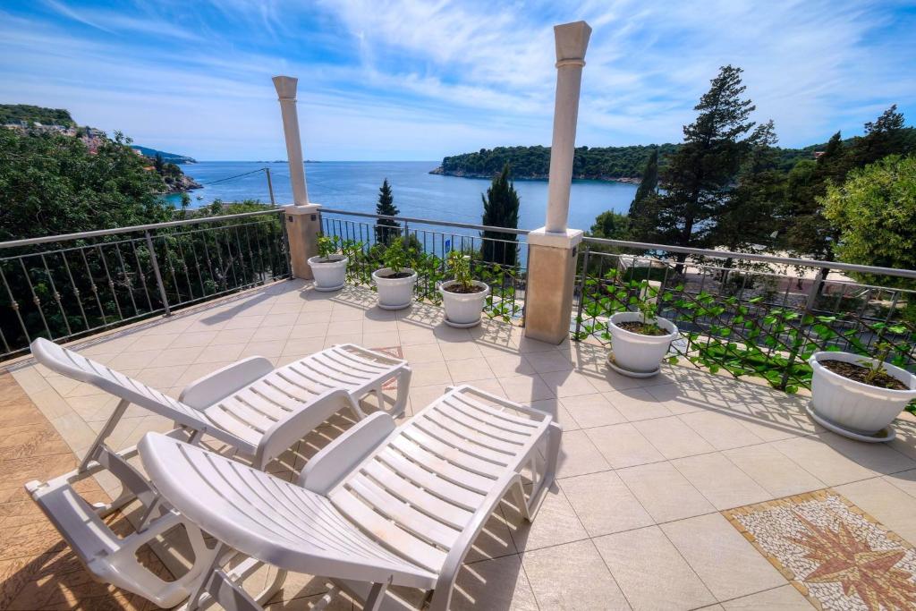 two white chairs sitting on a patio overlooking the ocean at Apartmani Antony in Zaton