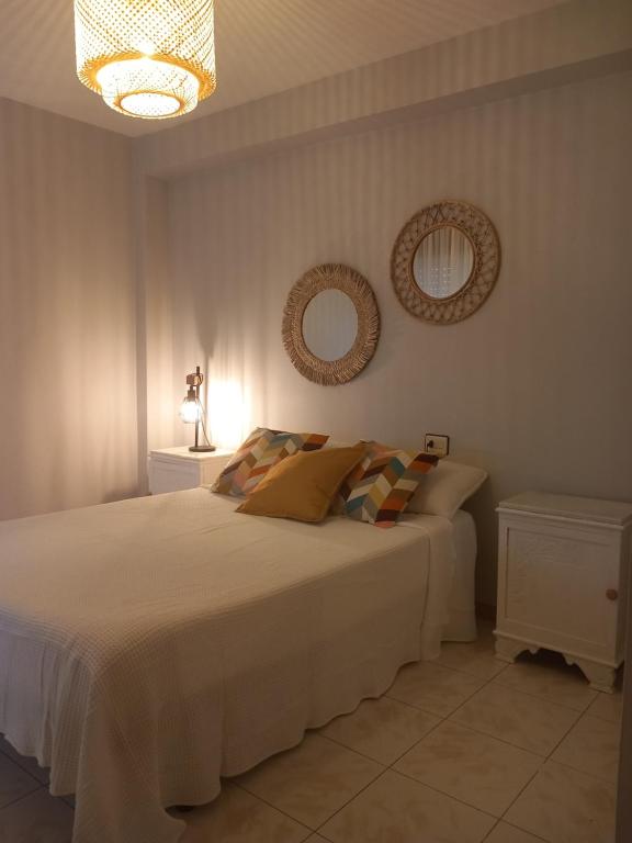 een slaapkamer met een bed met twee spiegels aan de muur bij La Aurora in Camariñas