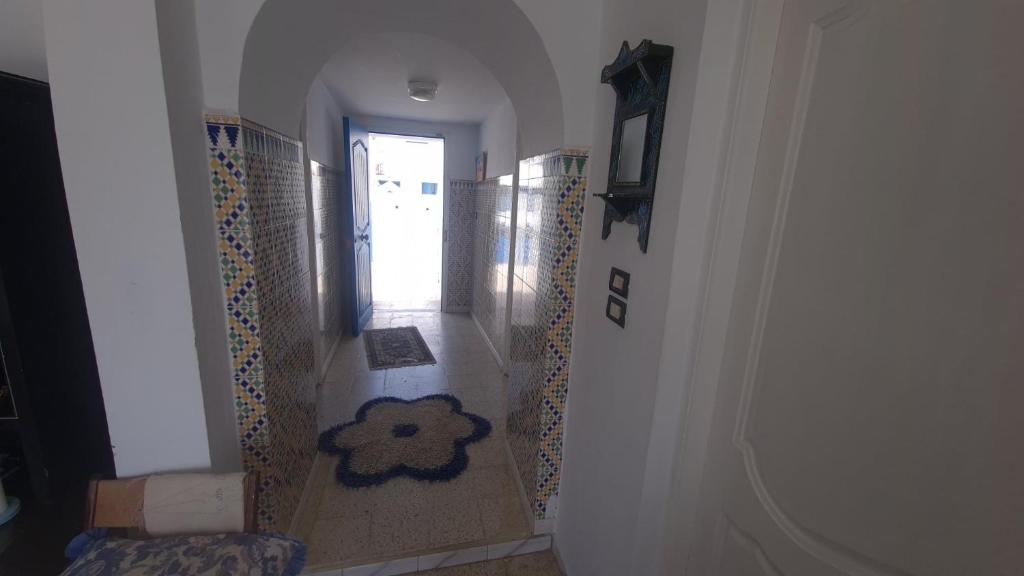 a hallway with a stairway with a door and a rug at Pied dans l’eau in Kelibia