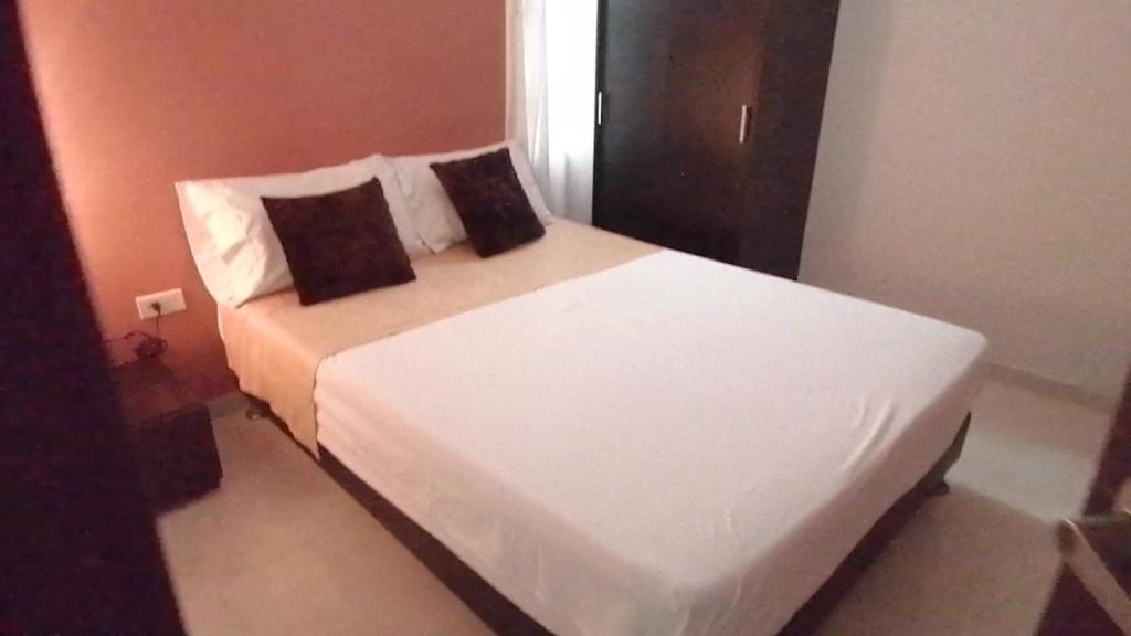 1 dormitorio con 1 cama blanca y 2 almohadas en ALIIKA HOTEL en Albania