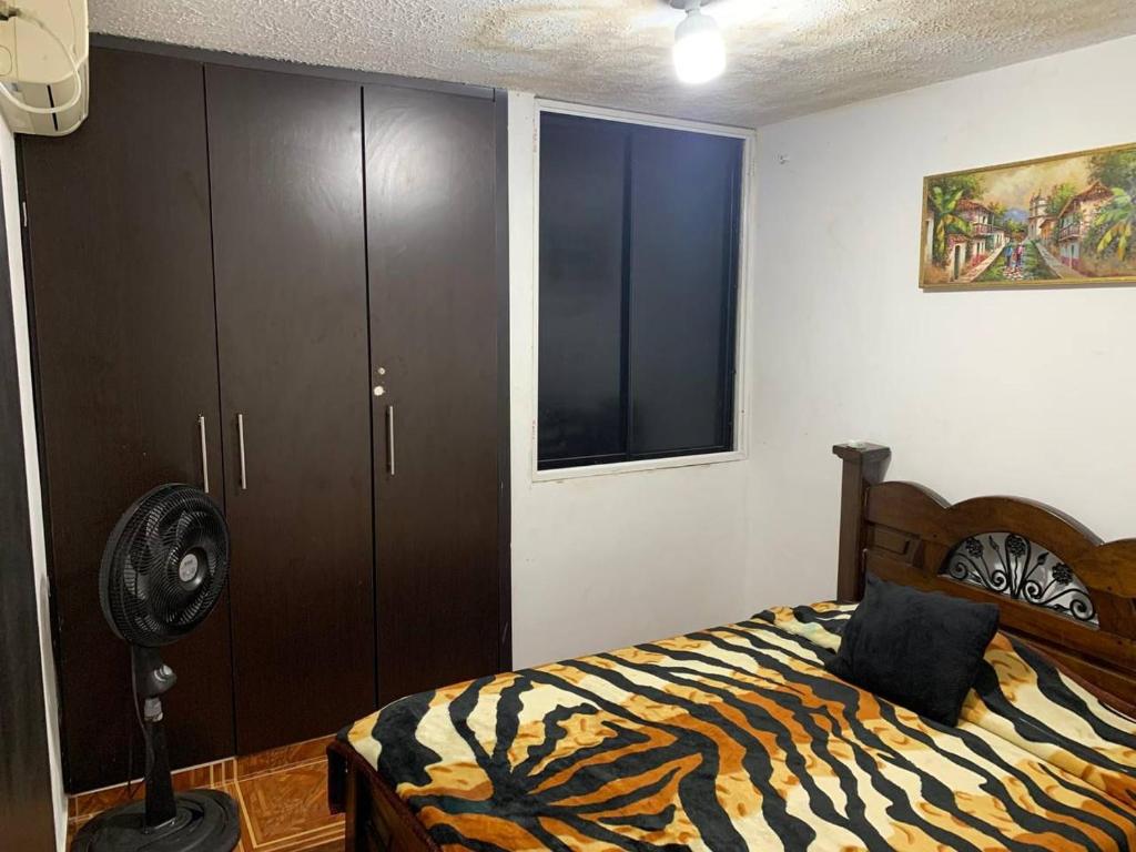 a bedroom with a bed and a fan and a window at Apartamentosla23 in Valledupar