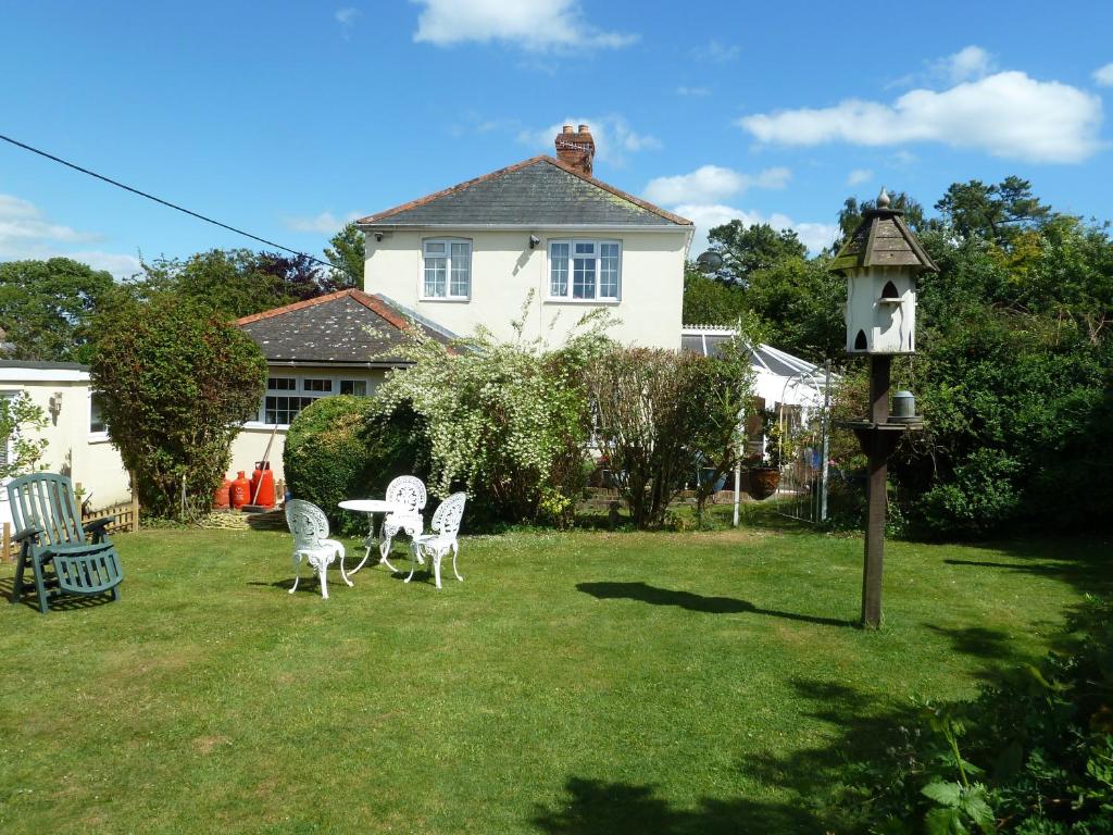 a yard with a table and chairs and a bird house at Hillside Self Catering in Salisbury