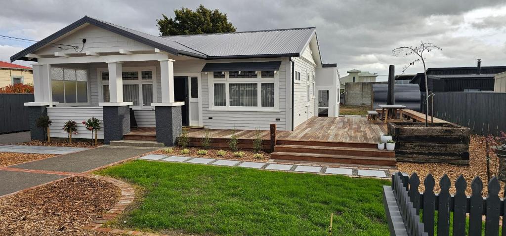 a white house with a fence in front of it at Che Bella in Martinborough