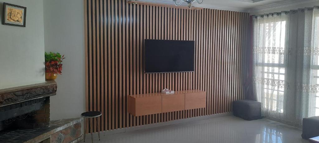 a living room with a television on a wall at Tranquil Oasis in the Heart of Ifrane in Ifrane