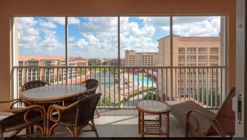 Westgate Town Center Resorts في أورلاندو: شرفة مع طاولة وكراسي ونافذة كبيرة