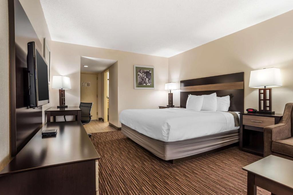 a hotel room with a large bed and a desk at Best Western Oak Manor in Biloxi