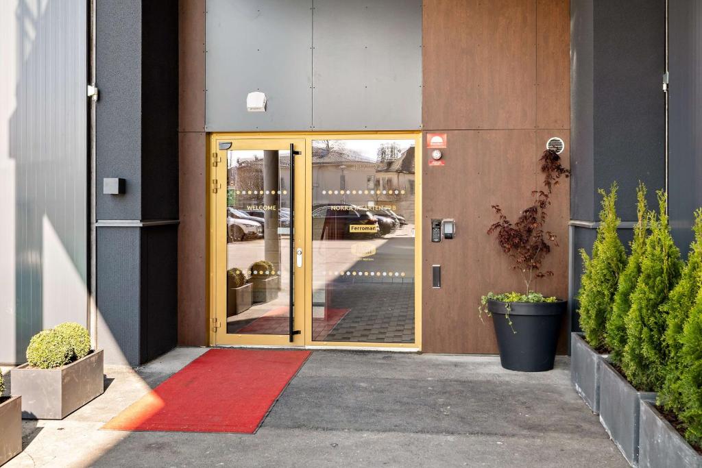 una porta aperta di un edificio con tappeto rosso di Aiden by Best Western Karlstad Arena a Karlstad